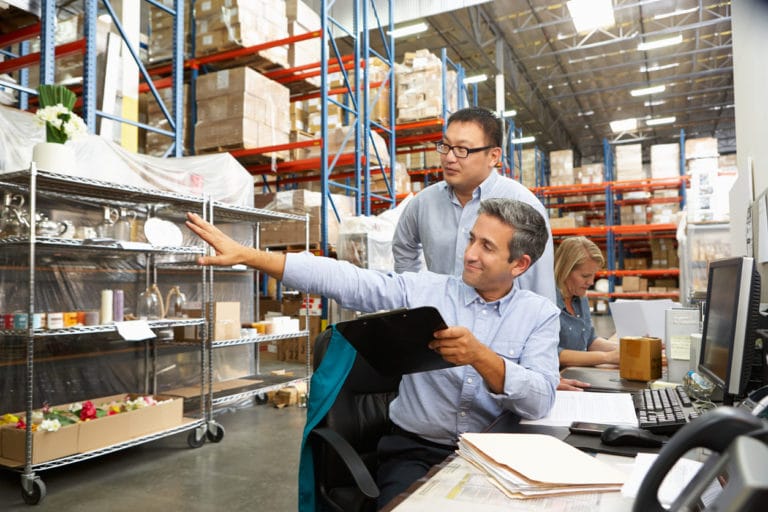 Operations Managers collaborating at a desk in warehouse